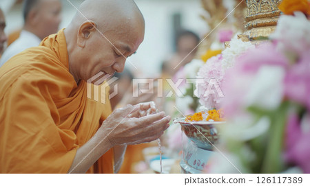 Buddhist monk participating in a traditional water blessing ceremony during Thai Songkran festival 126117389