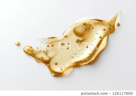 Realistic liquid gold cosmetic gel swatch isolated on a white background, a golden, glowing smudge with bubbles, top view. 126117600