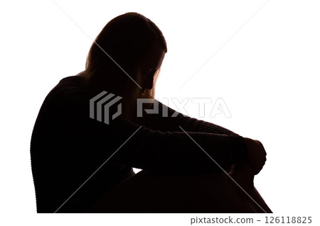 Silhouette of young woman sitting with loose hair, depressed Silhouette of young woman sitting with loose hair, depressed 126118825