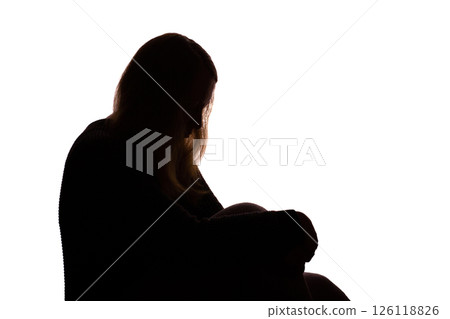Silhouette of young woman sitting with loose hair, depressed Silhouette of young woman sitting with loose hair, depressed 126118826