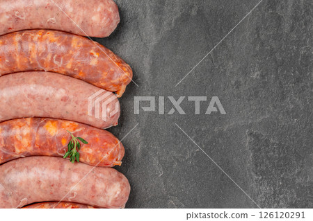 Assorted raw sausages bratwurst with spices for grill or barbeque on a stone board. Top view. Copy space Assorted raw sausages bratwurst with spices for grill or barbeque on a stone board. Top view. Copy space 126120291