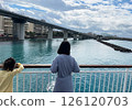 A quiet moment for sisters as they look out over the seaside city from a boat 126120703
