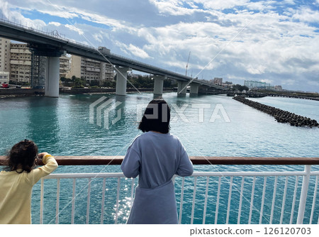 A quiet moment for sisters as they look out over the seaside city from a boat 126120703