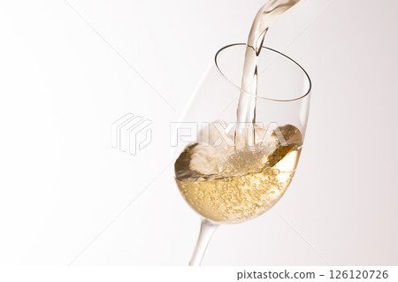 Pour white wine into the glass 126120726