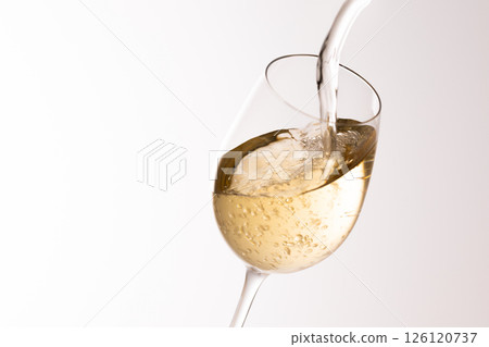 Pour white wine into the glass 126120737