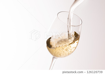 Pour white wine into the glass 126120739