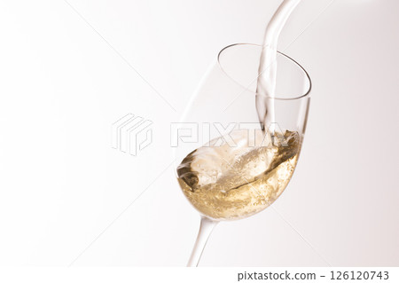 Pour white wine into the glass 126120743