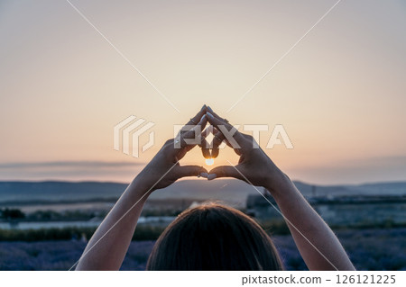 Sunset Hands Heart: Silhouette person forms heart shape at sunset symbolizing hope, love, peace. Sunset Hands Heart: Silhouette person forms heart shape at sunset symbolizing hope, love, peace. 126121225