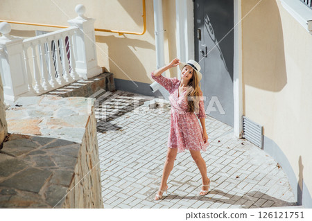woman in summer pink dress and hat on street smiling woman in summer pink dress and hat on street smiling 126121751
