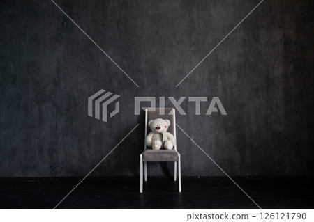 One with a soft toy in the interior of a gray room 126121790
