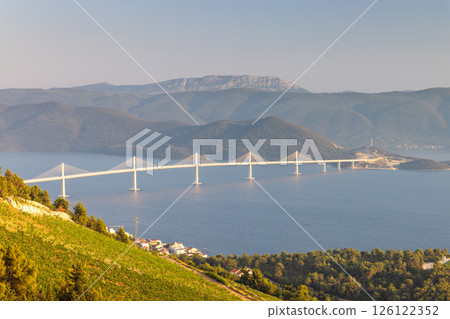 The Peljesac Bridge to Peljesac peninsula in Croatia, Europe. Majestic bridge spanning the sea, connecting landscapes under a clear sky. A blend of nature and architecture. 126122352