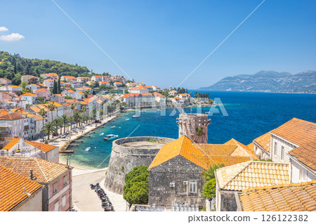 Korcula town in island of Korcula in Adriatic sea in Croatia, Europe. Picturesque coastal town with historic architecture, turquoise waters, and lush greenery under a clear blue sky. 126122382