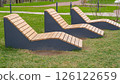 Empty wooden deck chairs or sun beds in city park. Concept of recreation, tanning 126122659