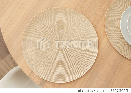 Minimalist aesthetic woven placemat on wooden table 126123055