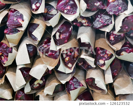 Traditional dessert made from nuts and dried fruits wrapped in paper at a local market Traditional dessert made from nuts and dried fruits wrapped in paper at a local market 126123532