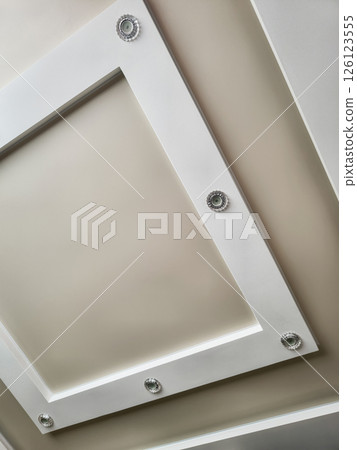 Unique ceiling design featuring recessed lighting in a modern interior space 126123555