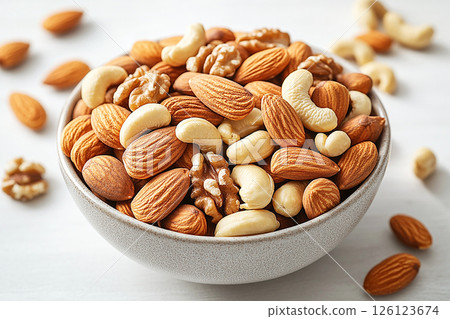 Healthy mix of almonds, walnuts and cashews in a white bowl. Healthy mix of almonds, walnuts and cashews in a white bowl. 126123674
