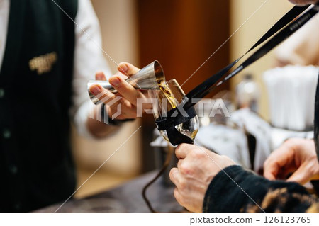 Mixing a cocktail with precision in a vibrant bar atmosphere after sunset 126123765