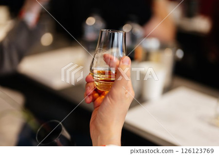 Enjoying a fine glass of whiskey during a relaxing evening gathering Enjoying a fine glass of whiskey during a relaxing evening gathering 126123769