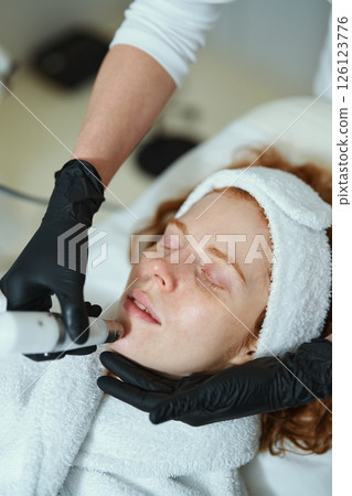 Client receiving skincare treatment at a spa during a relaxing session Client receiving skincare treatment at a spa during a relaxing session 126123776