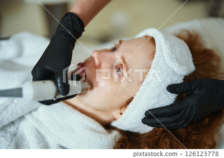 Woman receiving facial treatment at a spa during the day Woman receiving facial treatment at a spa during the day 126123778