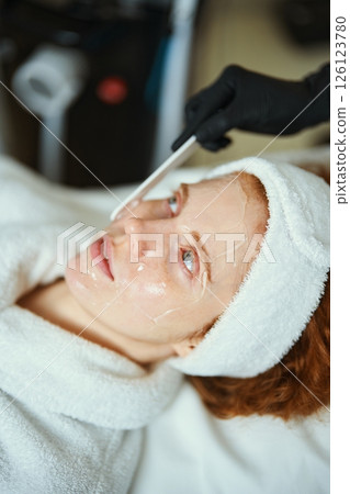 Skincare treatment session with patient relaxing on treatment bed Skincare treatment session with patient relaxing on treatment bed 126123780