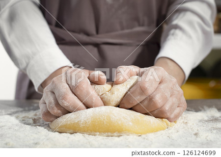 Baking concept. Caucasian female hands kneading the dough. 126124699