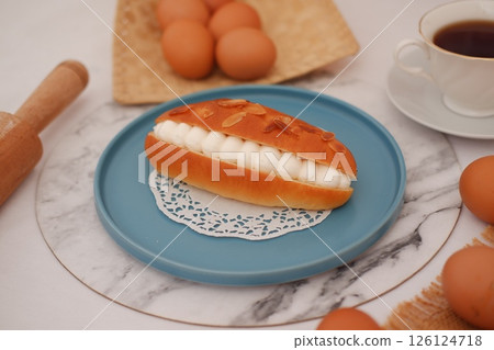 Cream-Filled Almond Pastry on a Plate with Eggs Cream-Filled Almond Pastry on a Plate with Eggs 126124718