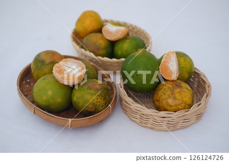 Vibrant pile of mandarins, showcasing fresh citrus fruits and peeled segments Vibrant pile of mandarins, showcasing fresh citrus fruits and peeled segments 126124726
