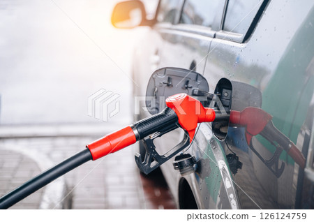 Fill the car with fuel. The car is filled with gasoline at a gas station. Gas station pump. Fill the car with fuel. The car is filled with gasoline at a gas station. Gas station pump. 126124759