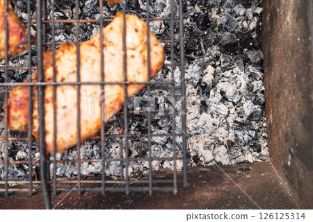 Warm, rustic tones highlight perfectly charred chicken, radiating a sense of home cooking and delightful indulgence 126125314