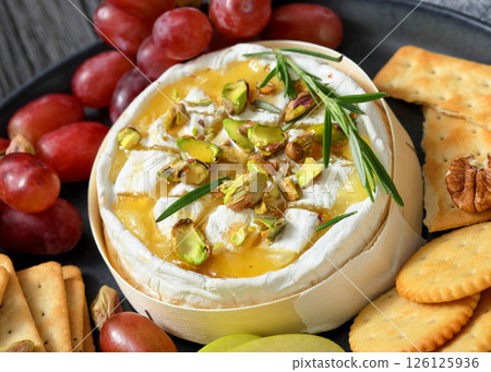 Baked Camembert with honey, pistachios, top view Baked Camembert with honey, pistachios, top view 126125936