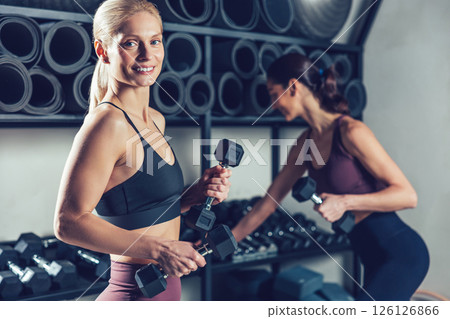 Fit and sporty young caucasian women with dumbbells in the gym 126126866