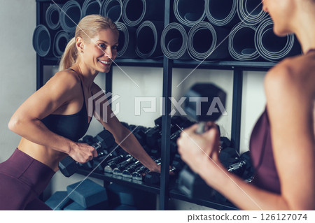 Two young caucasian women spending time together in the gym Two young caucasian women spending time together in the gym 126127074