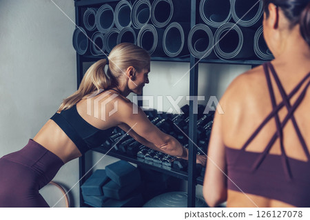Two young caucasian women spending time together in the gym Two young caucasian women spending time together in the gym 126127078