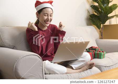 Celebrate on Christmas or new year season, asian woman hold a present box make video call during social distance, showing present, gift box on merry x'mas. 126127247