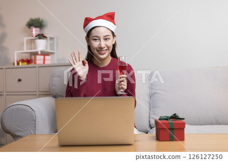Celebrate on Christmas or new year season, asian woman hold a present box make video call during social distance, showing present, gift box on merry x'mas. 126127250