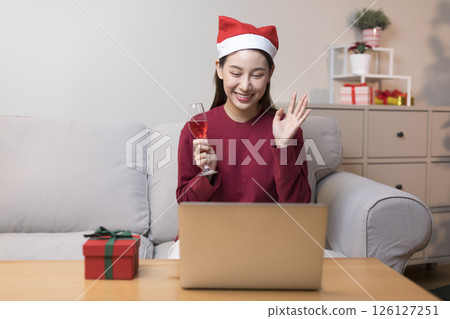 Celebrate on Christmas or new year season, asian woman hold a present box make video call during social distance, showing present, gift box on merry x'mas. 126127251