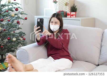 Beautiful Asian woman feel lonely and depressed with smartphone at home during Christmas holiday season. Beautiful Asian woman feel lonely and depressed with smartphone at home during Christmas holiday season. 126127353