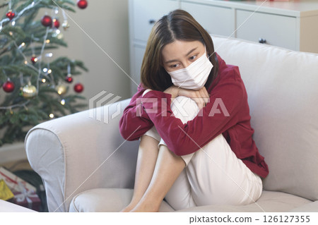 Beautiful Asian woman feel lonely and depressed with smartphone at home during Christmas holiday season. Beautiful Asian woman feel lonely and depressed with smartphone at home during Christmas holiday season. 126127355