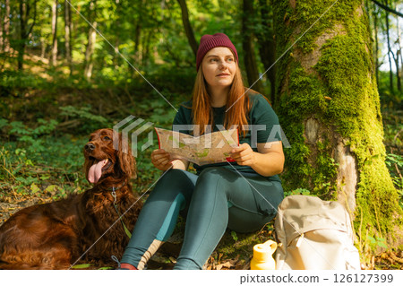 Woman with Map and Dog Resting in Forest 126127399
