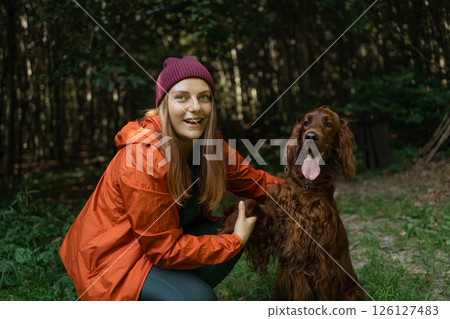 Woman Hiking with Irish Setter in Forest Woman Hiking with Irish Setter in Forest 126127483