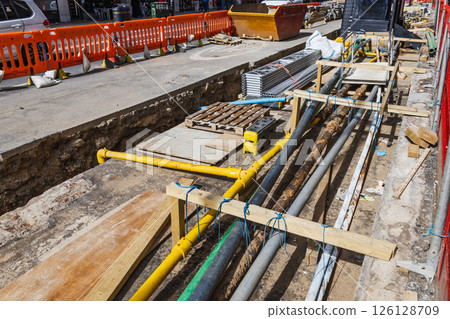 Detailed View of Construction Trench with Pipes and Cables Being Laid for Utility Services 126128709