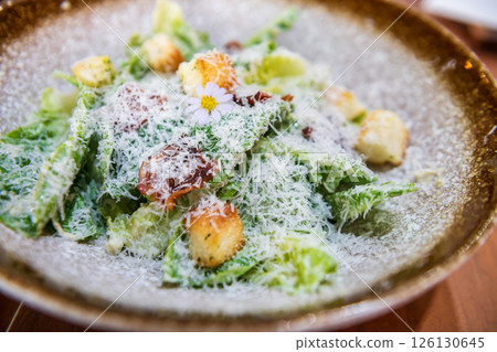 Portion of caesar salad with crispy bacon and bread on plate Portion of caesar salad with crispy bacon and bread on plate 126130645