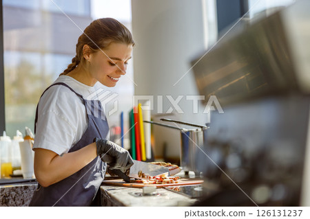 A dedicated barista expertly preparing fresh ingredients in a vibrant modern coffee shop A dedicated barista expertly preparing fresh ingredients in a vibrant modern coffee shop 126131237