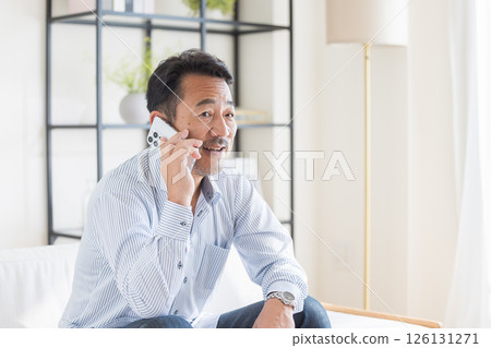A man who uses smartphones in the living room 126131271