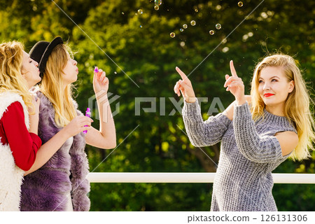 Women blowing soap bubbles, having fun 126131306