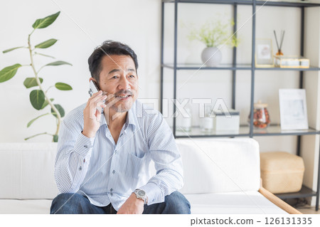 A man who uses smartphones in the living room 126131335