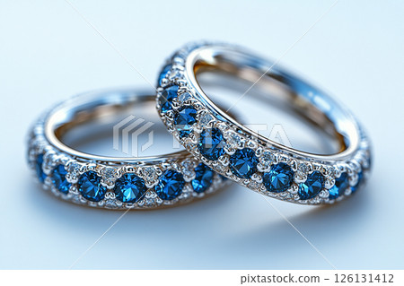 Luxurious pair of wedding rings with blue stones on a white background. Rococo-Renaissance style. Luxurious pair of wedding rings with blue stones on a white background. Rococo-Renaissance style. 126131412