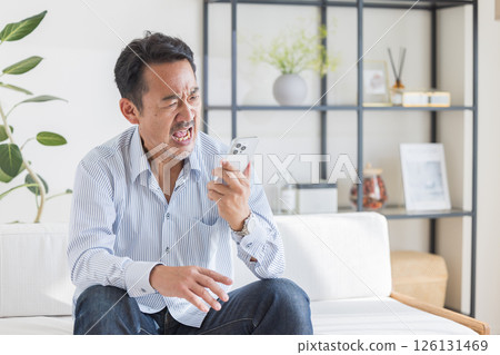 A man who uses smartphones in the living room 126131469